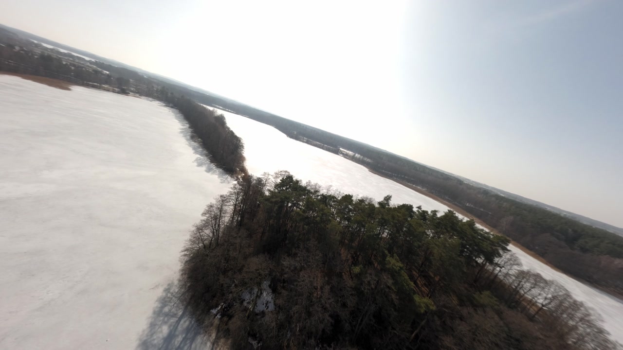 Cinematic drone view of icy lake in Masurian countryside