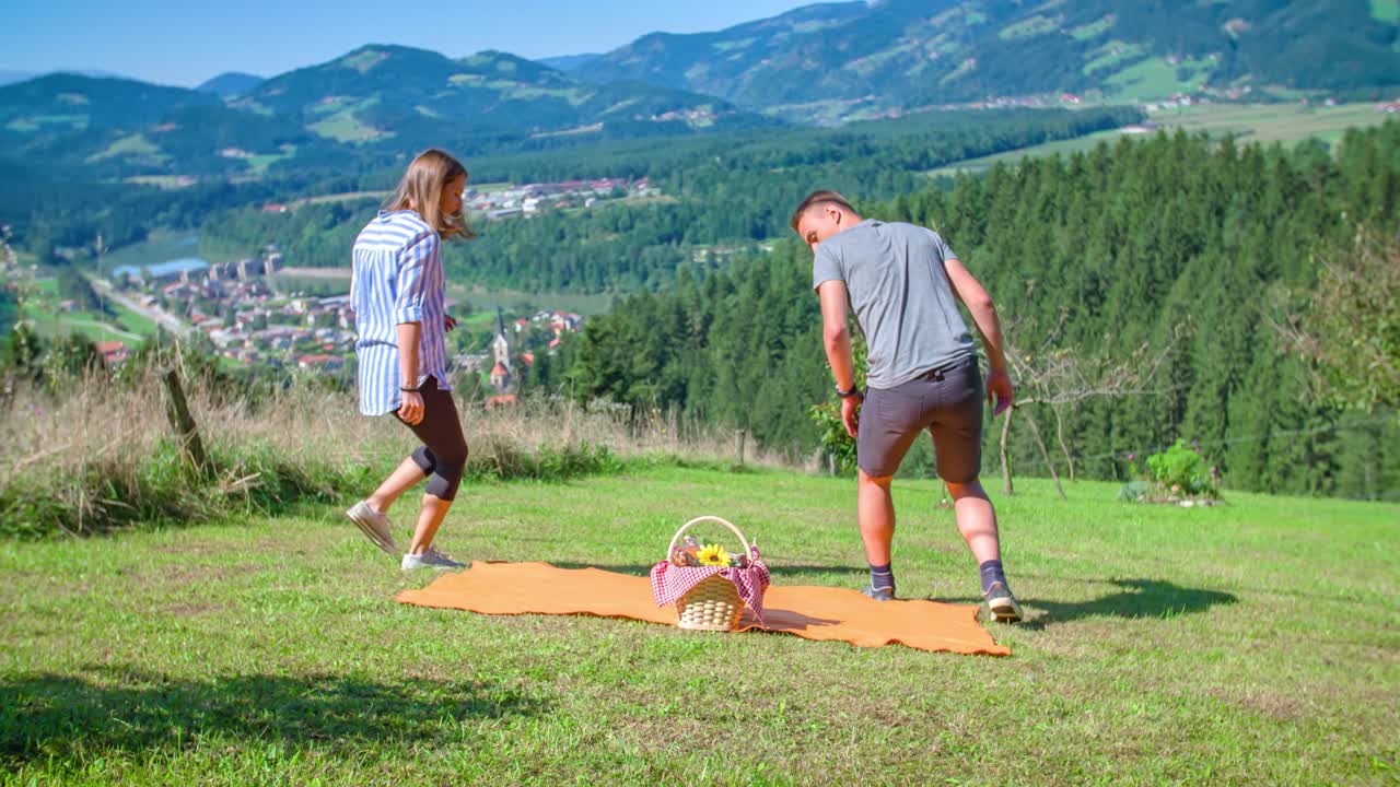 Парень и девушка идут с корзиной еды на романтический пикник