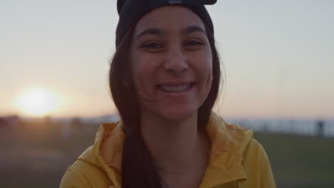 close up portrait of awkward teenage girl smiling cheerful looking at camera wearing braces enjoying park at sunset