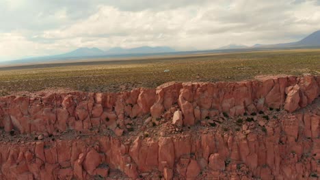 lonely vehicle on a desert road near a cliff