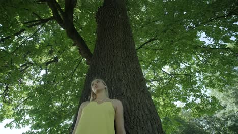 happy beautiful young girl dancing of freedom in summer park with trees in the background.