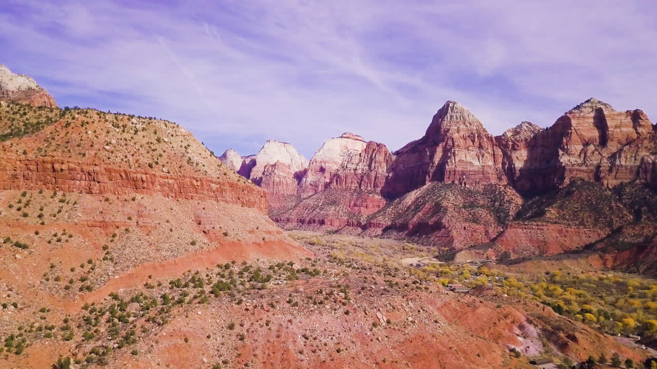 Wide aerial reveal of an epic mountain range and canyon below