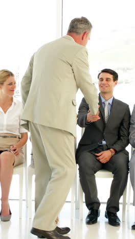 businessman taking applicant away to be interviewed
