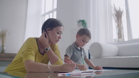 Mamá-E-Hijo-Sentados-En-La-Mesa-Del-Espejo-En-La-Habitación-Blanca-Dibujan-Con-Lápices-De-Colores-Sonriendo-Y-Riendo