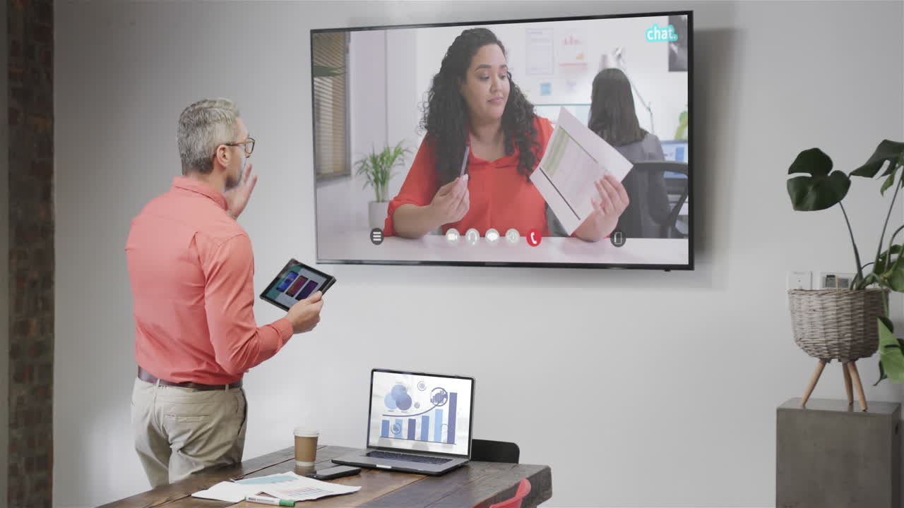 백인 사업가 가 텔레비전 화면 에서 백인 여성 동료 와 비디오 통화 를 하고 있다