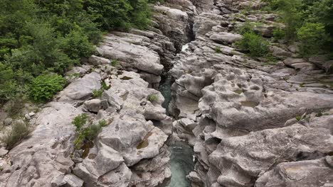 Narrow-rocky-gorge-with-flowing-river-in-Maggiatal-Vallemaggia,-Ticino,-Switzerland