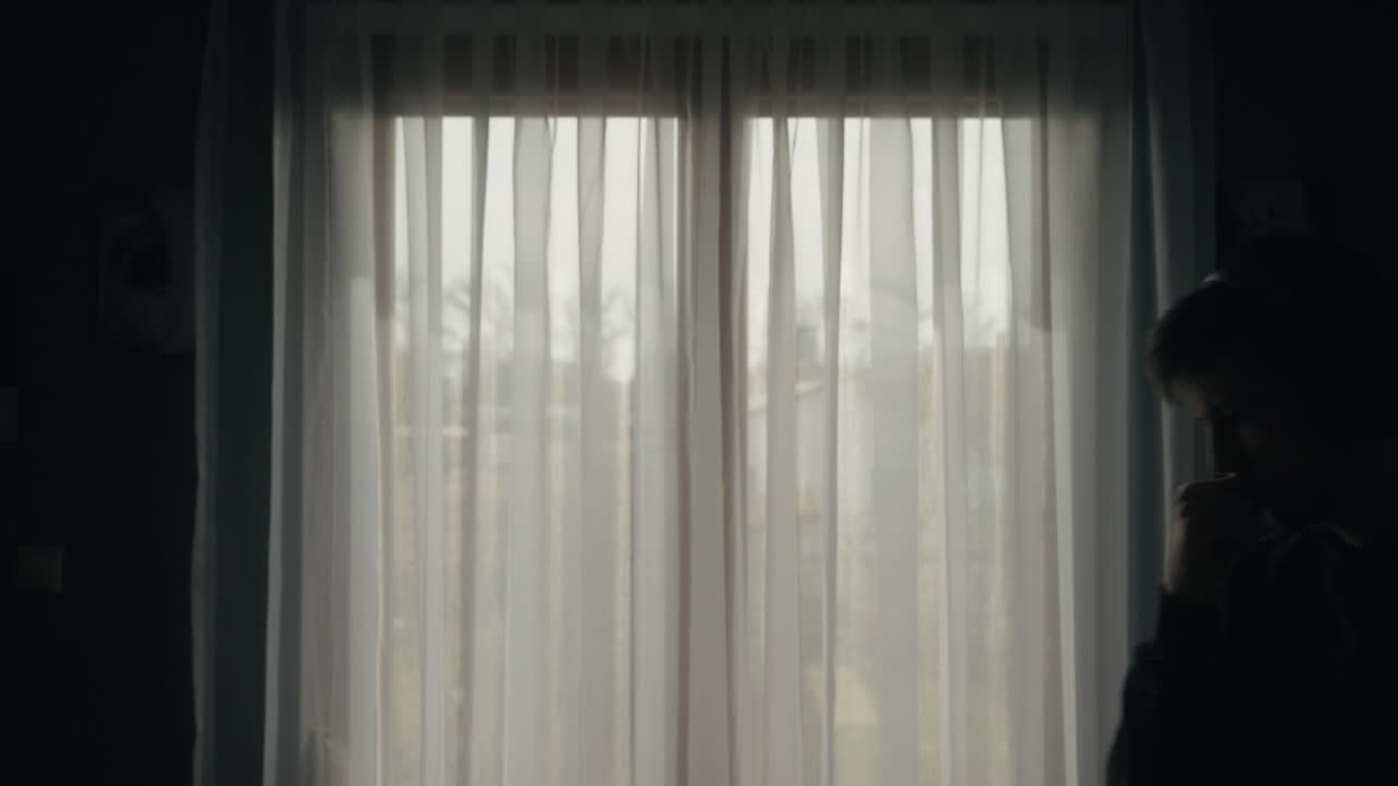 Boy thinking in front of a window