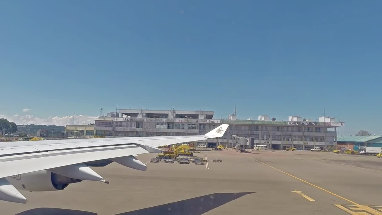 Plane taxing on the airport, View through an airplane window of the airport building and plane's wings