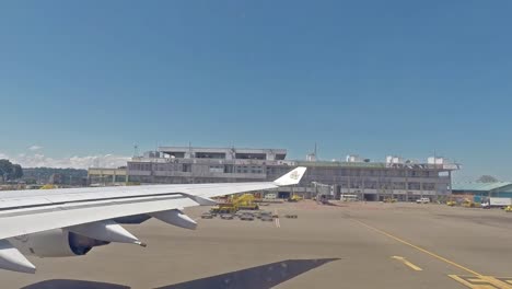 plane taxing on the airport, view through an airplane window of the airport building and plane's wings