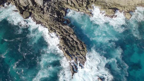 Turquoise-ocean-waves-crashing-on-cliffs-in-porte-d'enfer,-Guadeloupe