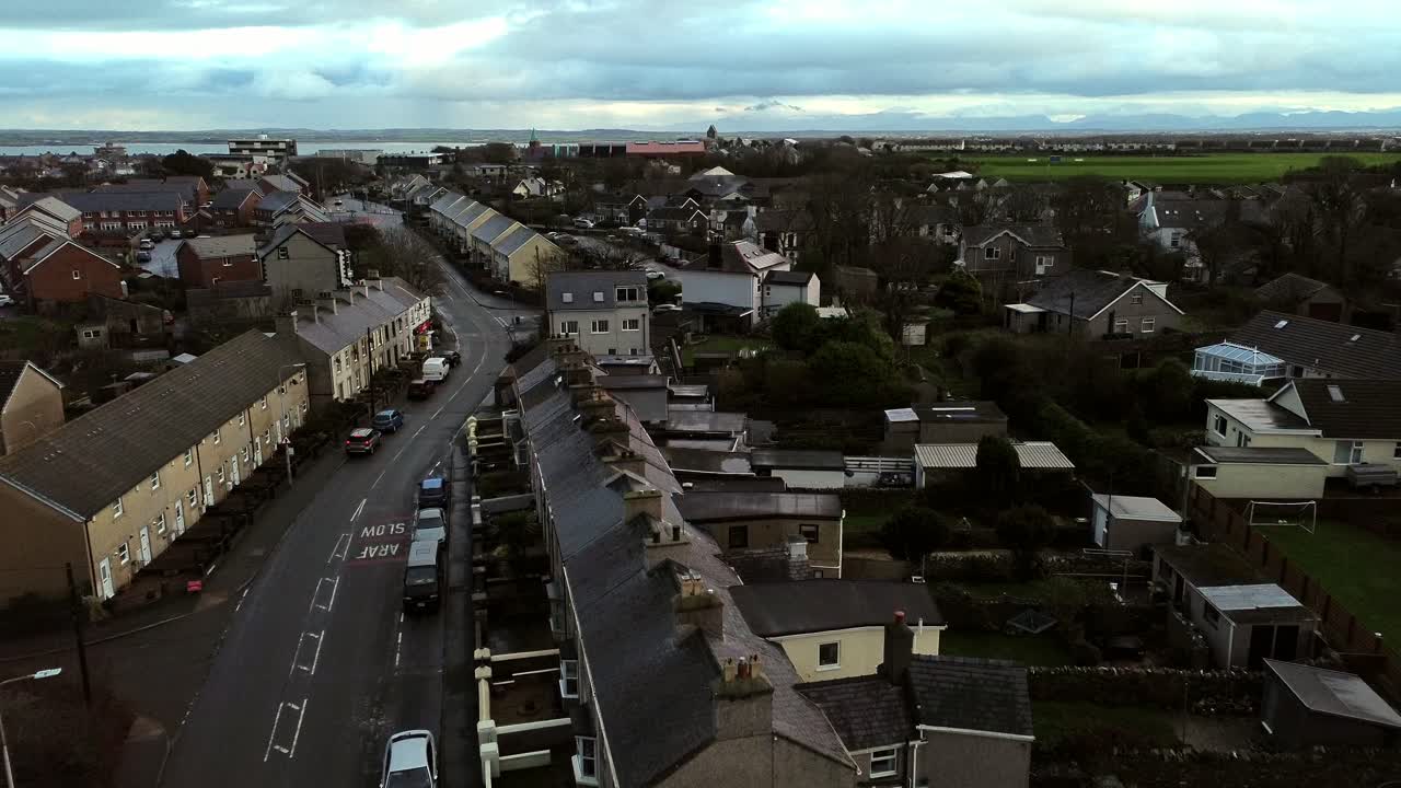 Rainy Holyhead homes aerial view descent towards small island town neighbourhood real estate