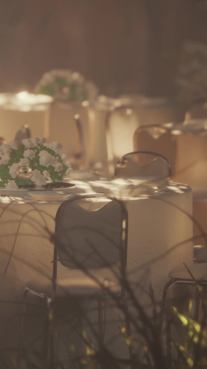 Tables are set for an outdoor gathering in a garden area during sunset
