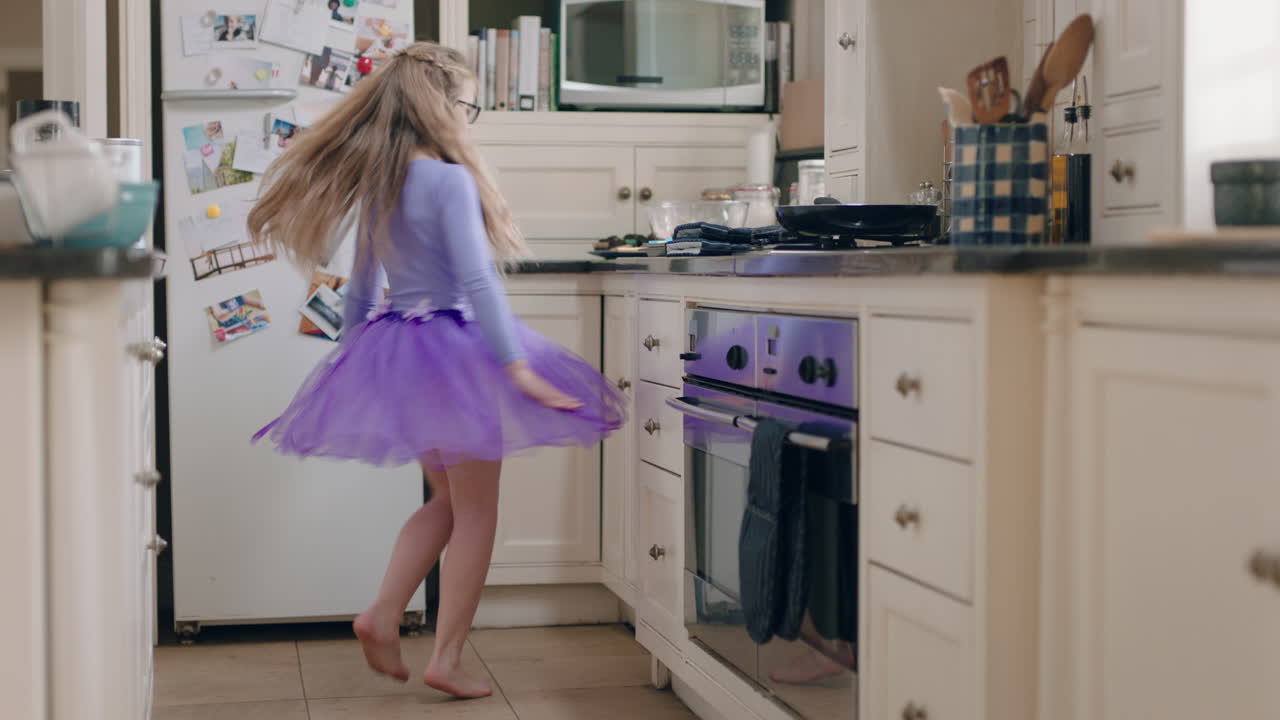 una bailarina feliz bailando en la cocina divirtiéndose practicando movimientos de baile de ballet usando tutu púrpura en casa