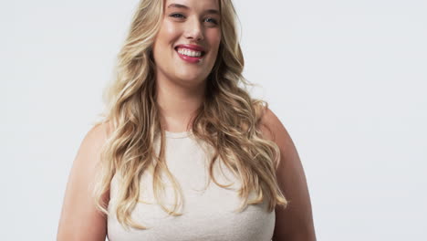 caucasian plus size woman with long blonde hair and blue eyes smiling in studio