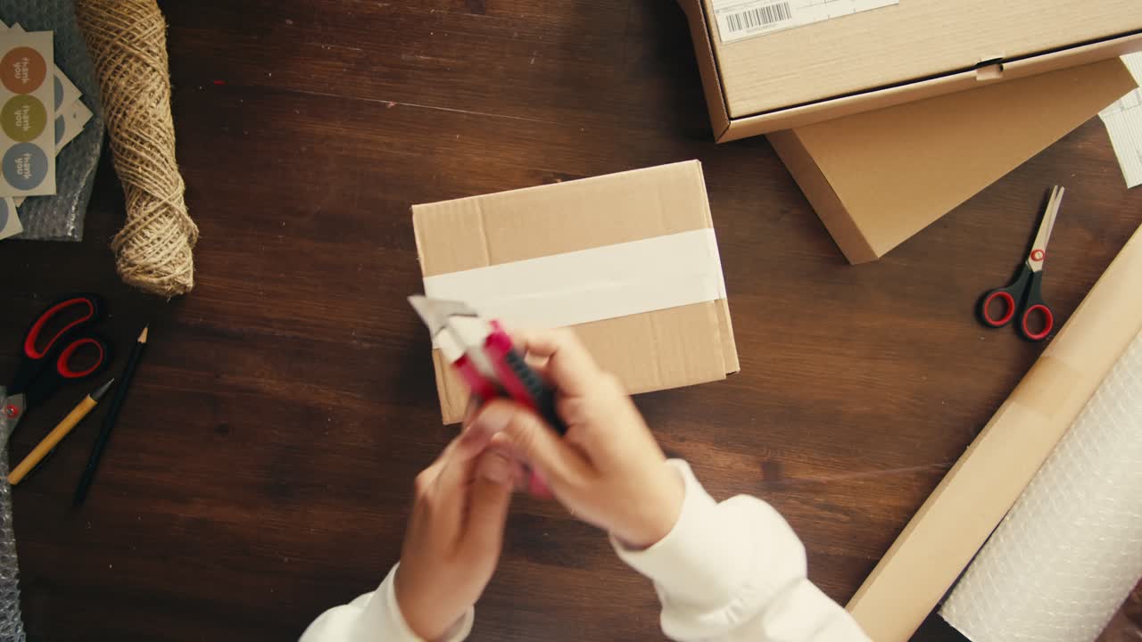 E-commerce storage shop, woman packing goods and clothes for second hand delivery market, dedicated Packaging and Shipping Workspace with Supplies and Technology for efficiency, online sales.