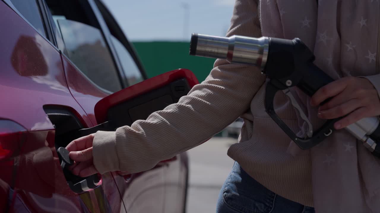 Woman Removing Fuel Nozzle and Opening Car's Fuel Cap