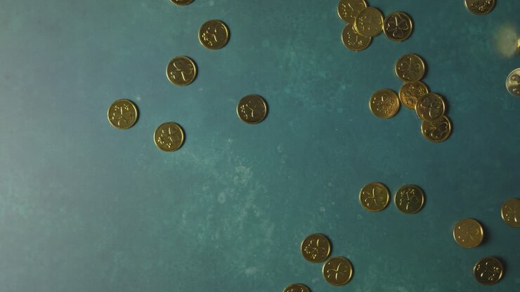 Overhead Studio Shot Of Gold Coins With Shamrock Symbol Thrown Onto Background To Celebrate St Patricks Day
