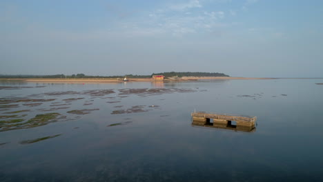 Low-Drone-Shot-over-Water-with-White-Birds-Flying-Away-in-Wells-Next-The-Sea-North-Norfolk-UK-East-Coast