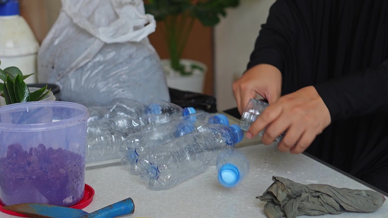 Video ASMR di giardinaggio sul taglio di bottiglie di plastica con le forbici per preparare fioriere fai-da-te.