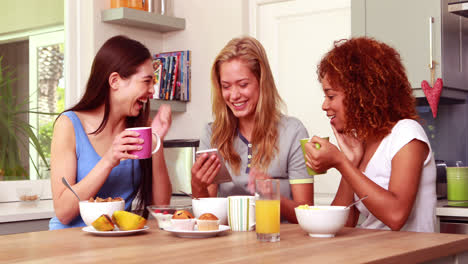 friends laughing while eating breakfast together