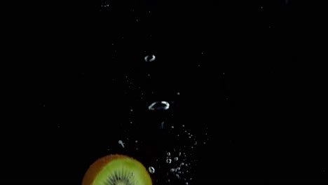 kiwi falling into water super slowmotion, black background, lots of air bubbles, 4k240fps