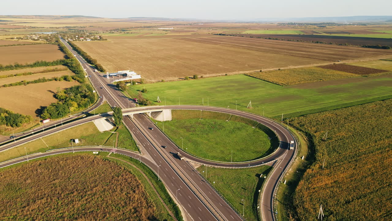 Aerial drone view of a road junction with moving cars and nature, greenery, fields, village, Moldova