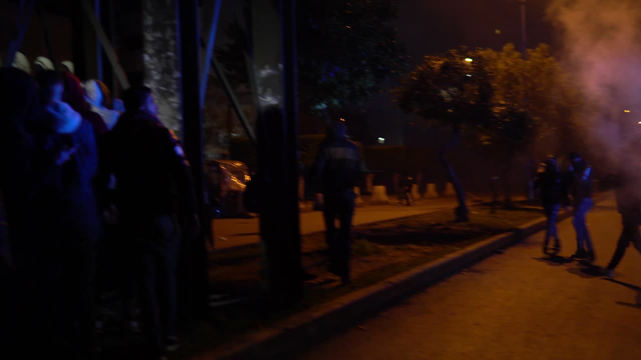 se ve a un hombre en una carretera ancha y vacía arrojando una bomba de humo durante la protesta celebrada en trípoli, líbano