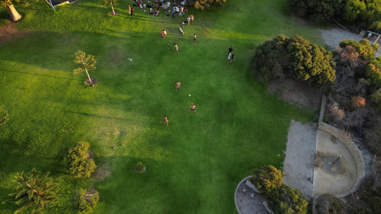 오스트레일리아 서부 프레망틀 의 사우스 비치 파크 에서 일몰 때 공 을 치고 있는 친구 들 의 느린 동작 촬영