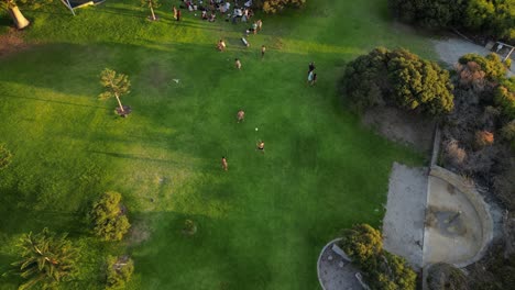 Toma-En-Cámara-Lenta-De-Amigos-Jugando-Con-Pelota-Al-Atardecer-En-South-Beach-Park-En-Fremantle,-Australia-Occidental