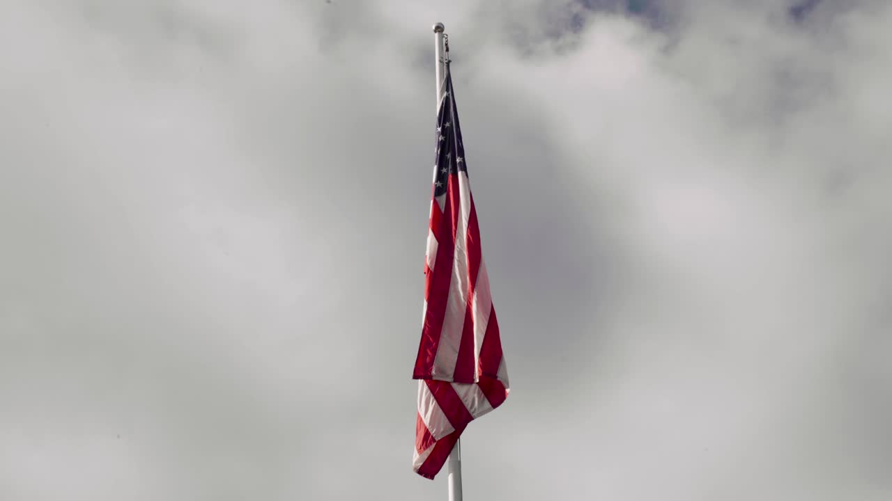 bandera estadounidense en la parte superior de un asta de bandera en un día nublado y tranquilo
