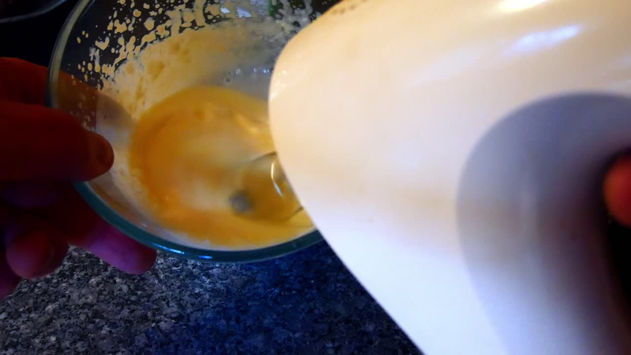 hacer una mezcla de crema batida casera batiendo con una batidora de cocina mirando hacia abajo