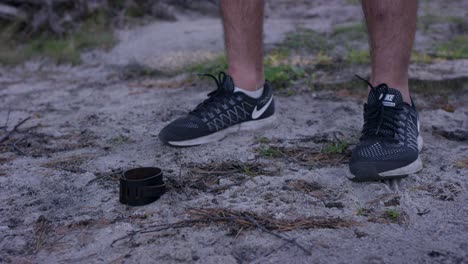 man picking up a wristband on the beach