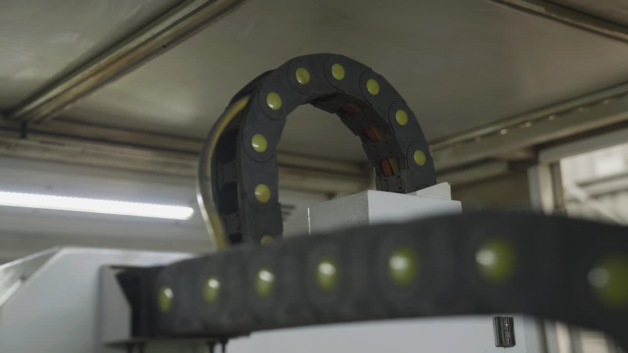 Cables rising above CNC machine moving along with programmed laser