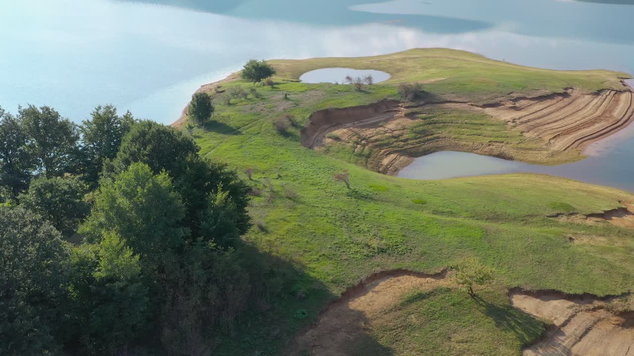 Rama Lake in Bosnia and Herzegovina over island with eroded shore and trees, Aerial flyover shot