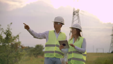 Engineers-in-uniform-working-with-a-laptop-near-transmission-lines.