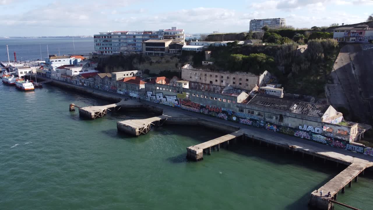 Drone shot flying over some abandoned factories in Cacilhas, Portugal, with a seagull flying very close to the camera