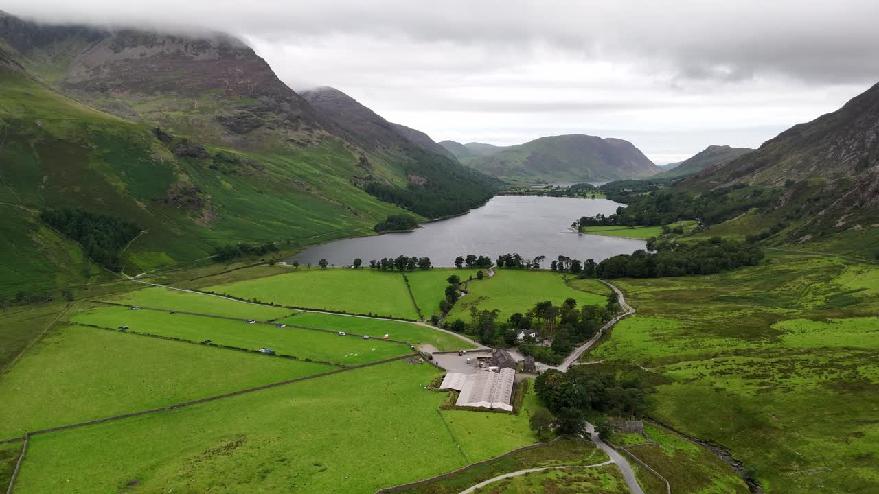 Aerial drone shot of Buttermere in the Lake District on a moody, overcast day with mountains, forest and lake