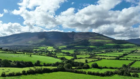 aerial comeragh mountains fly to over fertile green farmlands on a summer evening