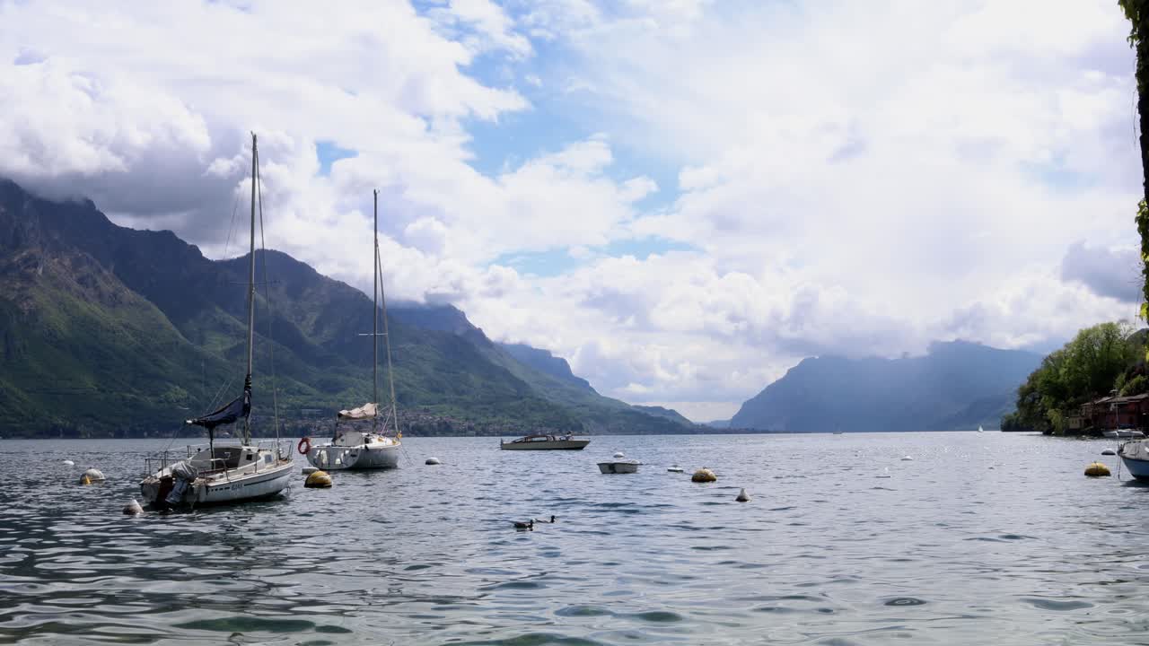 Boats in a port on a lake Como with bright cloudy sky