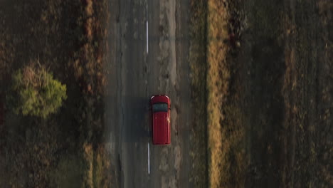 overhead tracking shot of a car driving along a country highway and drifting over the lines