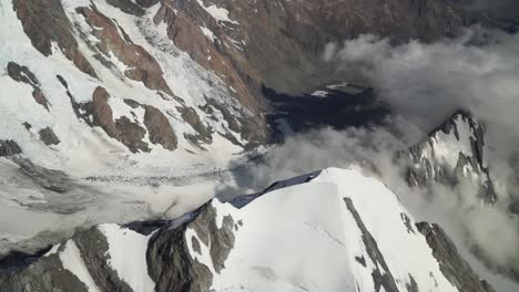 SLOWMO---Hookerglacier,-Southern-Alps,-New-Zealand-with-clouds,-snow-and-rocky-mountains-from-scenic-airplane-flight