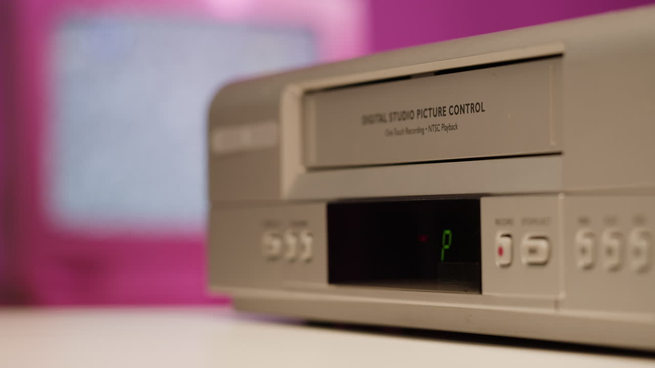 Hand loading a VHS tape into a VCR