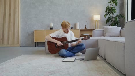 hombre aprendiendo guitarra en línea en casa