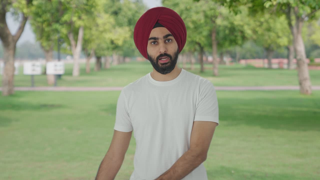 hombre indio sikh enojado gritando a alguien en el parque