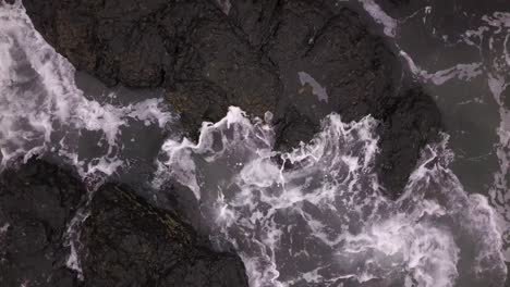 Aerial-view-of-waves-crashing-against-rocks