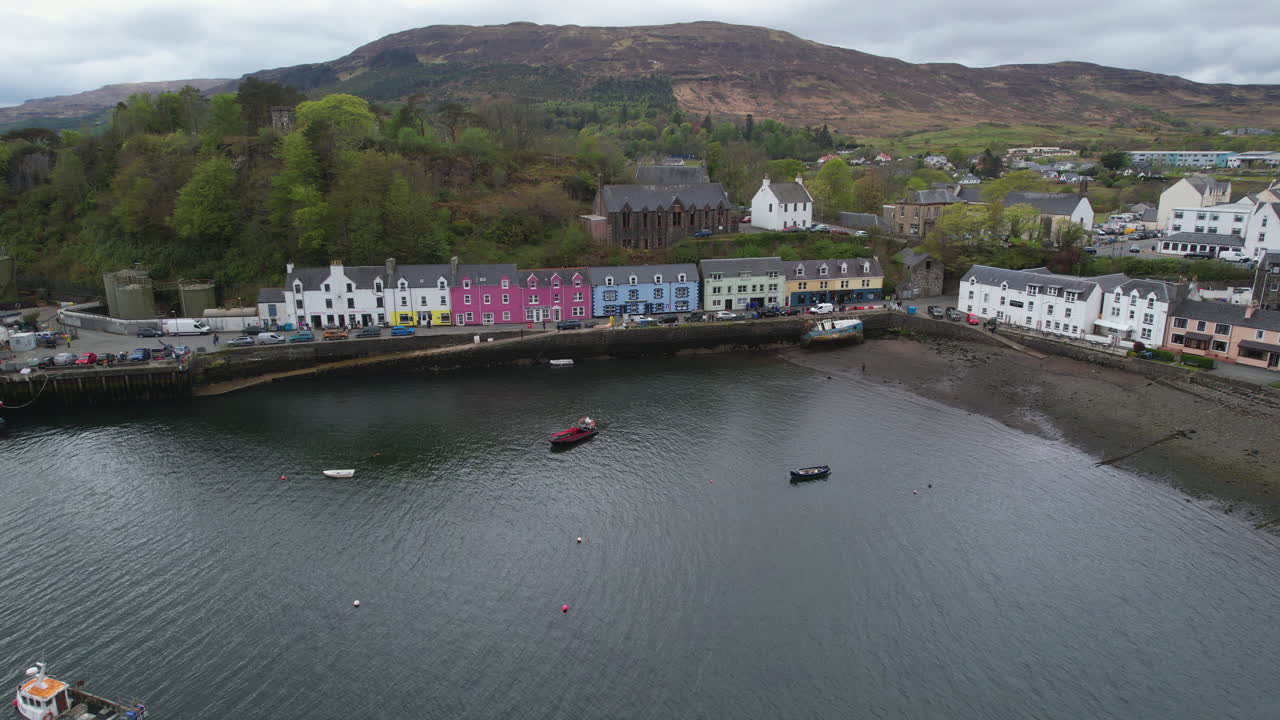 Aerial view of the colorful houses of Portree Harbour, Isle of Skye, Scotland, showing the bay and the boats