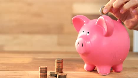 mujer poniendo monedas en la hucha