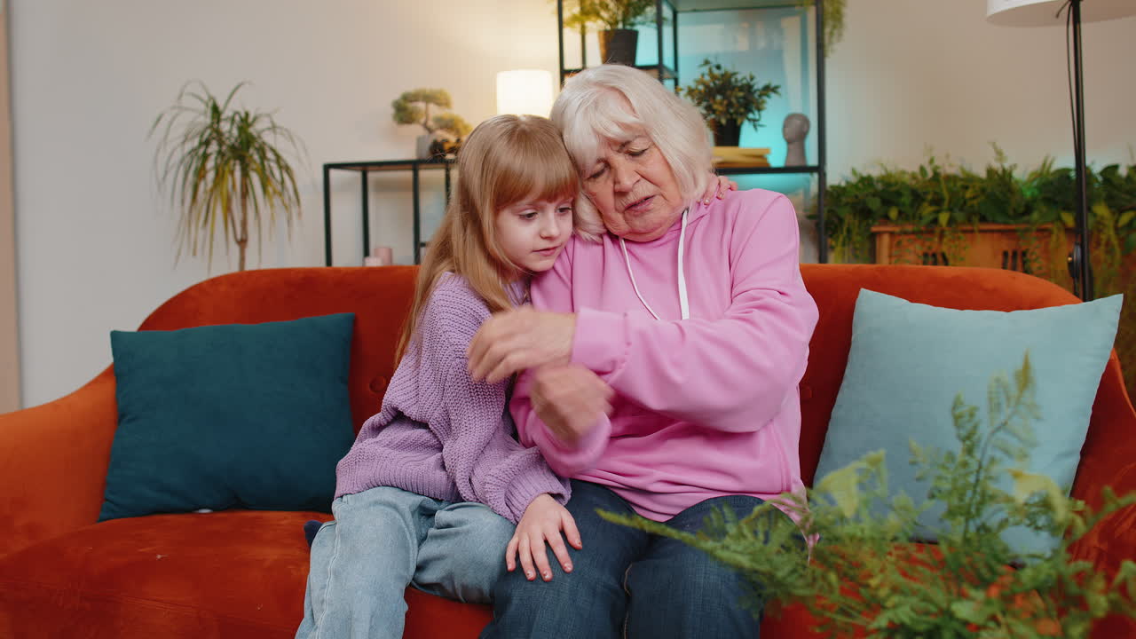 Nipote amorevole, preoccupata e gentile che consola la nonna in lacrime, aiutandola con empatia a risolvere un problema.