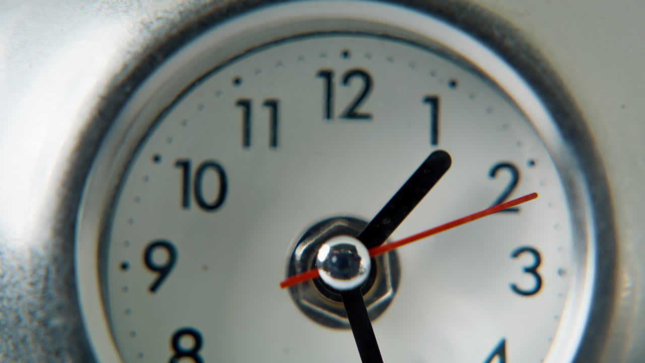 Macro circle clock dial with white background. Arrows running on round timepiece