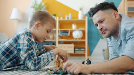 padre e hijo jugando al ajedrez en casa